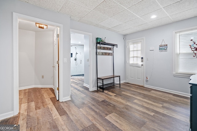 entryway featuring baseboards, recessed lighting, a drop ceiling, and wood finished floors