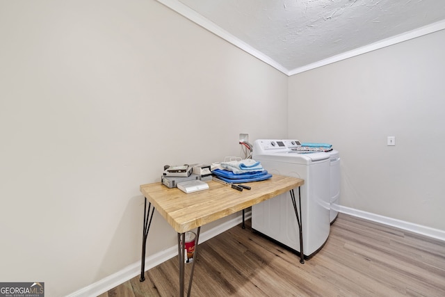 laundry area featuring crown molding, independent washer and dryer, laundry area, and light wood finished floors