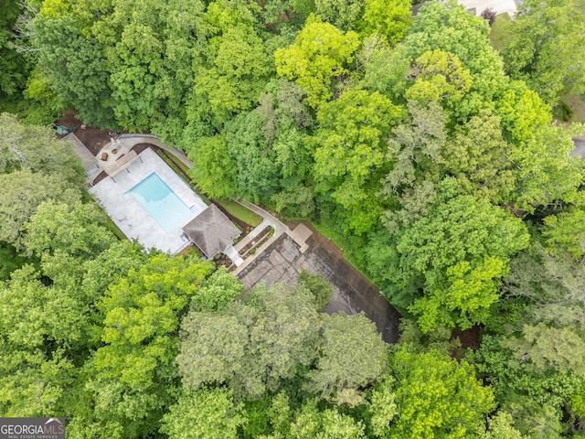 drone / aerial view with a wooded view