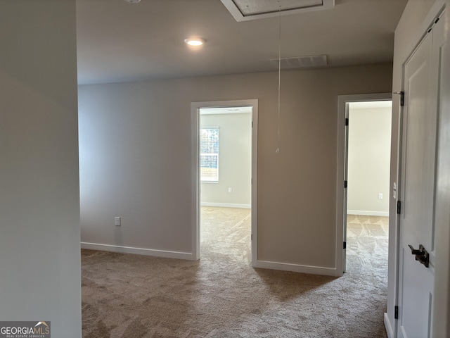 unfurnished room featuring attic access, visible vents, baseboards, carpet, and recessed lighting
