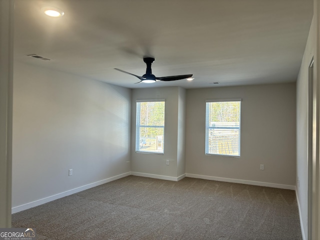 unfurnished room with carpet floors, a ceiling fan, baseboards, and visible vents