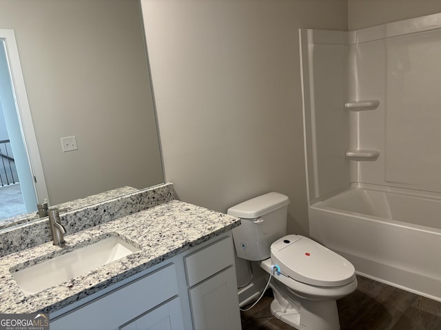 bathroom featuring toilet, bathtub / shower combination, wood finished floors, and vanity