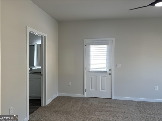interior space featuring baseboards, carpet flooring, and a ceiling fan