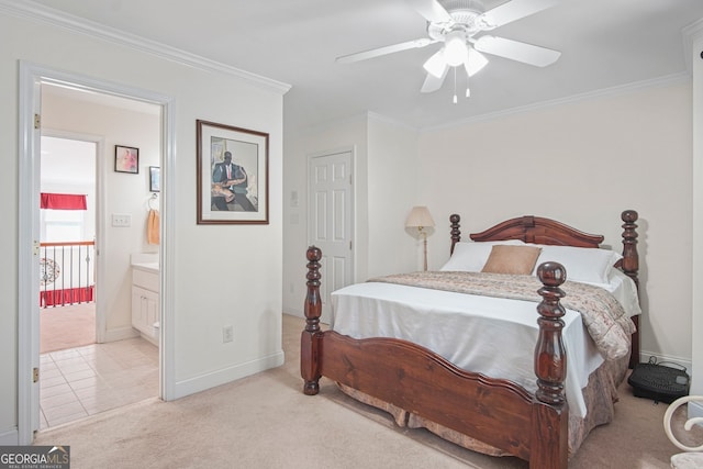 carpeted bedroom featuring crown molding, baseboards, ceiling fan, and ensuite bath