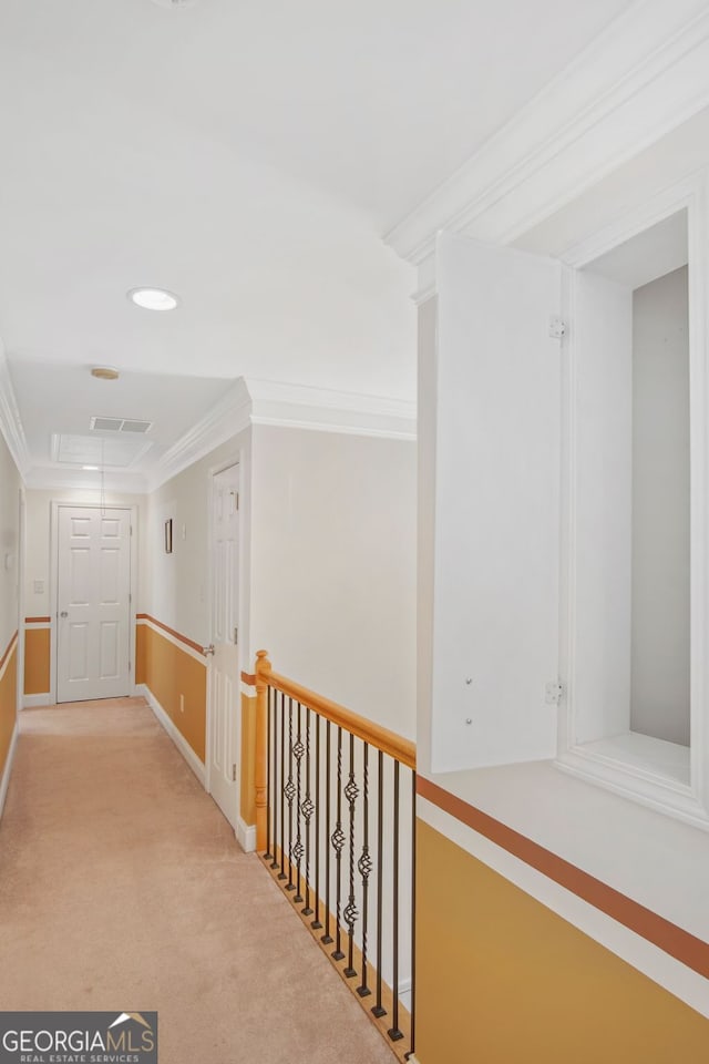 hallway with crown molding, carpet floors, attic access, baseboards, and visible vents