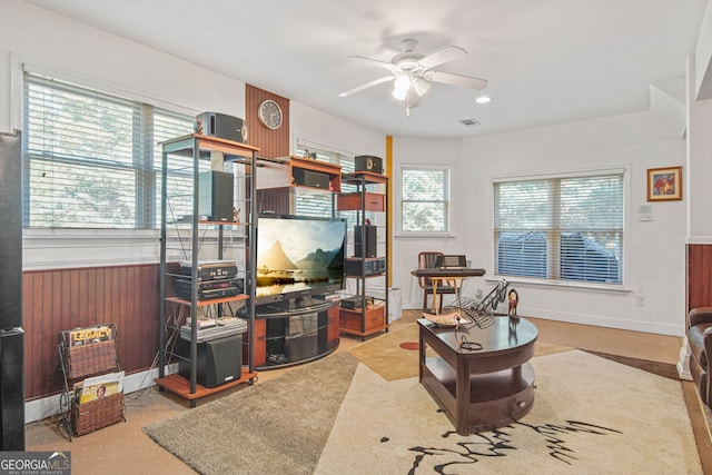 living area with ceiling fan and visible vents