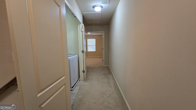 hallway with baseboards, visible vents, attic access, and light colored carpet