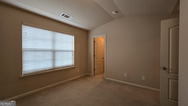 unfurnished bedroom featuring carpet flooring, baseboards, visible vents, and vaulted ceiling