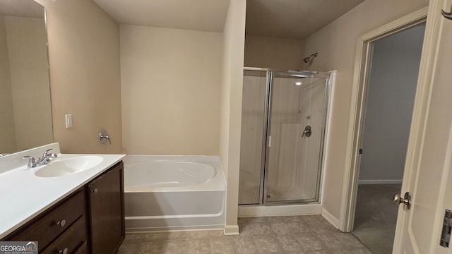 bathroom with vanity, baseboards, a bath, and a stall shower