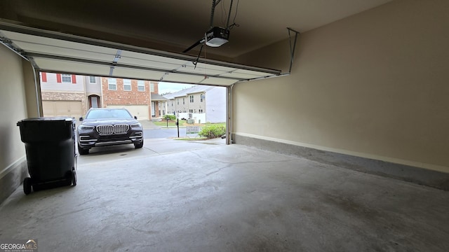 garage with baseboards and a garage door opener