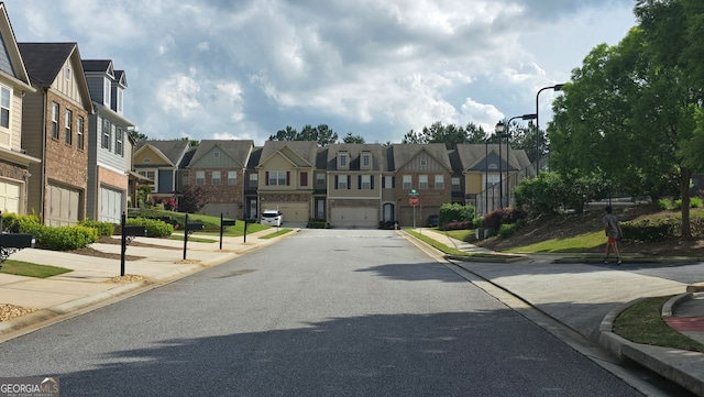 view of street with street lighting, a residential view, sidewalks, and curbs