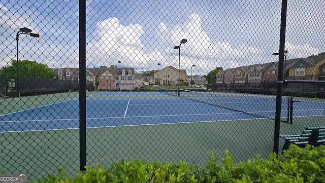 view of sport court featuring fence and a residential view
