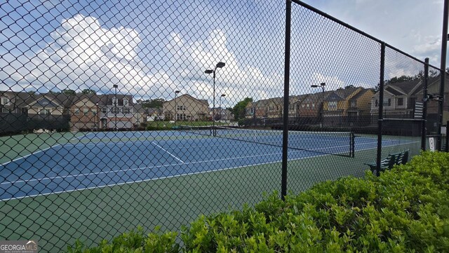 view of sport court featuring fence and a residential view