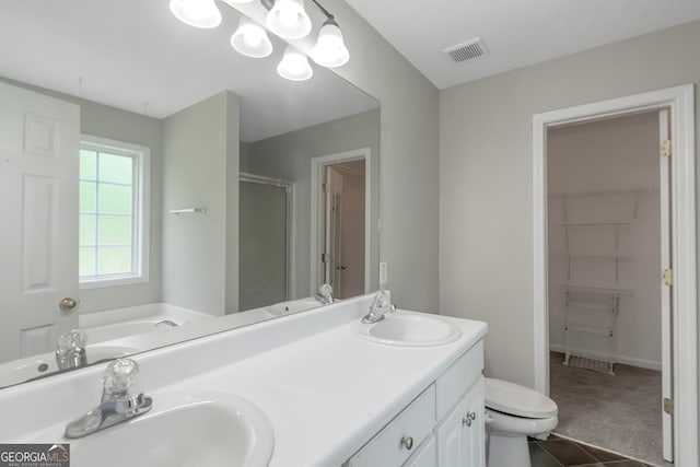 90 Heatherstone Way, Covington, GA 30016 - bathroom featuring toilet, visible vents, a shower stall, and a sink
