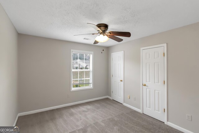 90 Heatherstone Way, Covington, GA 30016 - unfurnished bedroom featuring ceiling fan, carpet floors, a textured ceiling, baseboards, and visible vents