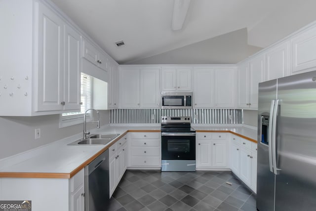 90 Heatherstone Way, Covington, GA 30016 - kitchen featuring visible vents, lofted ceiling, white cabinets, a sink, and stainless steel appliances