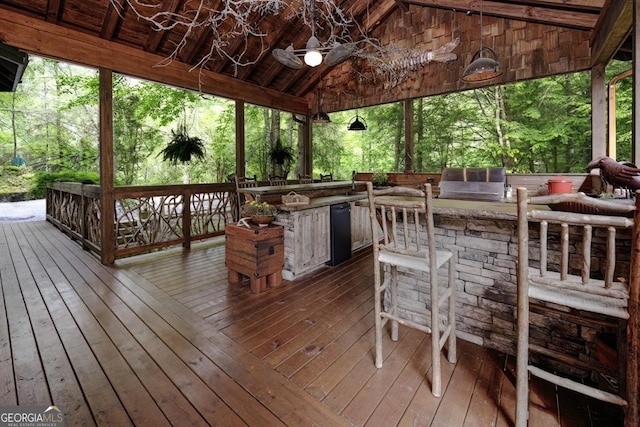 wooden deck with a ceiling fan, outdoor wet bar, and an outdoor kitchen