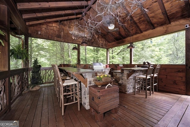 wooden deck with area for grilling, exterior kitchen, and outdoor wet bar