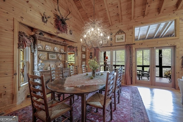 dining space featuring an inviting chandelier, wood walls, wood ceiling, and hardwood / wood-style floors