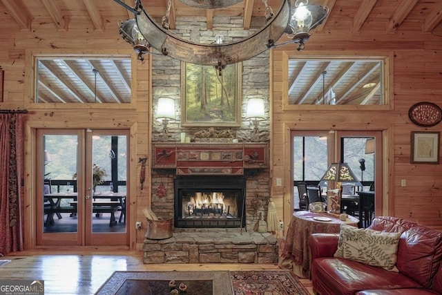 living room featuring wooden walls, beamed ceiling, french doors, and wood finished floors