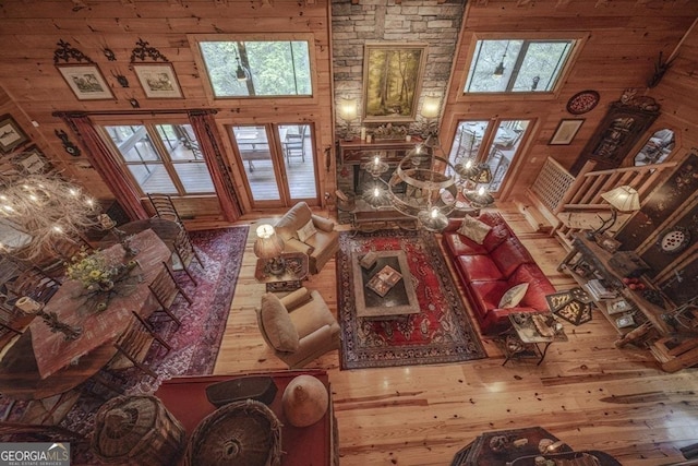 living area featuring wood-type flooring, a high ceiling, and wooden walls