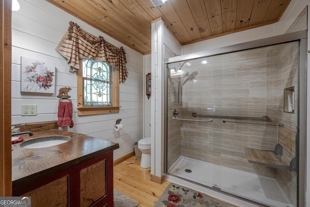 bathroom featuring vanity, wood finished floors, toilet, wooden ceiling, and a stall shower
