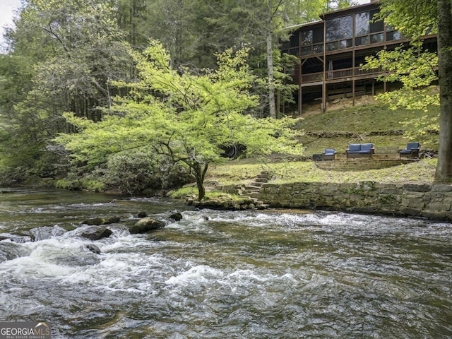 view of landscape with a water view and a wooded view