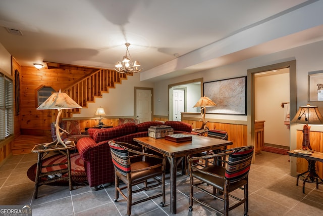 360 Cascade Pt, Ellijay, GA 30540 - dining room featuring wood walls, a chandelier, stairway, tile patterned floors, and wainscoting