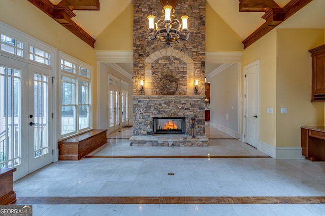unfurnished living room featuring high vaulted ceiling, a chandelier, french doors, baseboards, and a wealth of natural light
