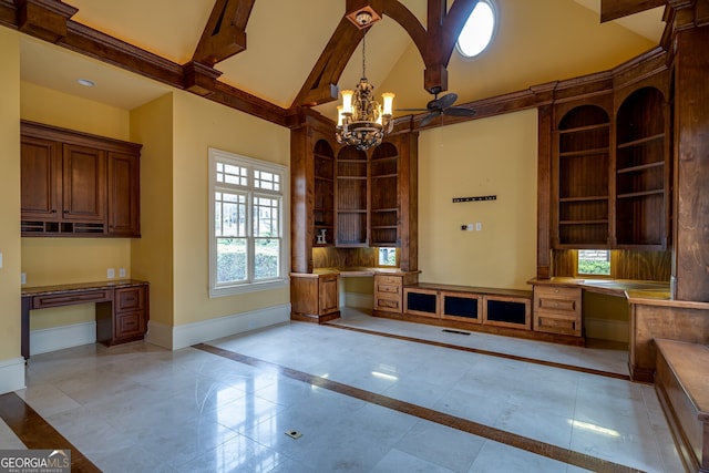 interior space with built in study area, high vaulted ceiling, built in features, ceiling fan with notable chandelier, and baseboards