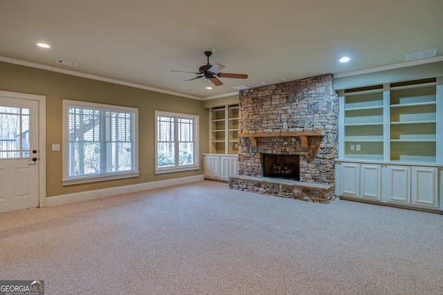 unfurnished living room with carpet flooring, ornamental molding, ceiling fan, and plenty of natural light