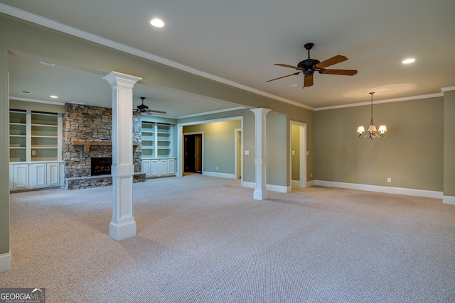 unfurnished living room with light carpet, a fireplace, decorative columns, and ceiling fan with notable chandelier