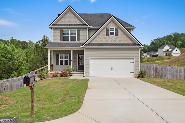 craftsman house with fence, covered porch, a front yard, and concrete driveway