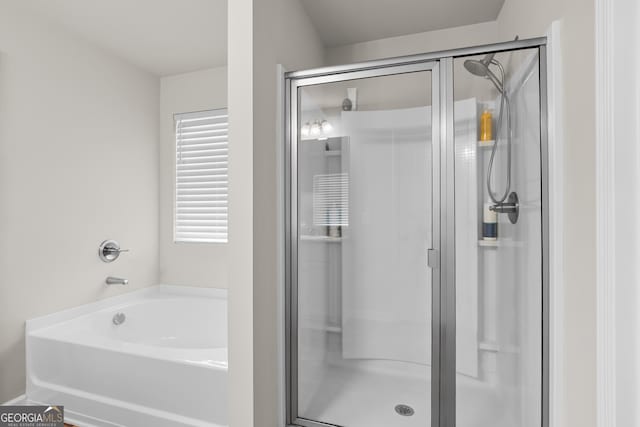 bathroom featuring a bath and a shower stall