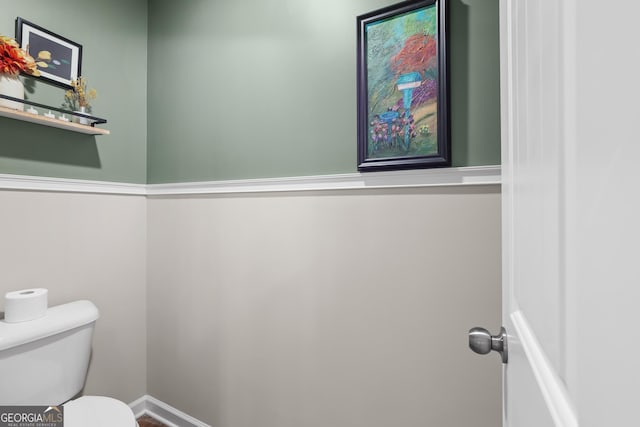 bathroom featuring baseboards and toilet