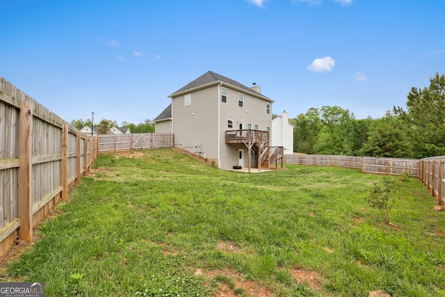 view of yard with a deck, stairs, and a fenced backyard