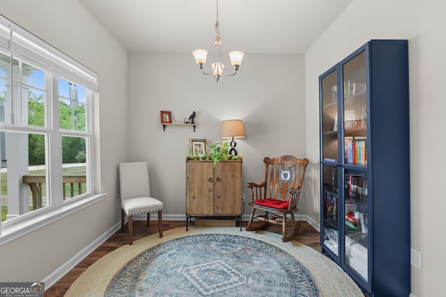 sitting room featuring baseboards, wood finished floors, and a notable chandelier