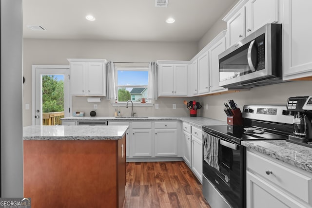 kitchen featuring dark wood-style flooring, visible vents, appliances with stainless steel finishes, a sink, and white cabinets