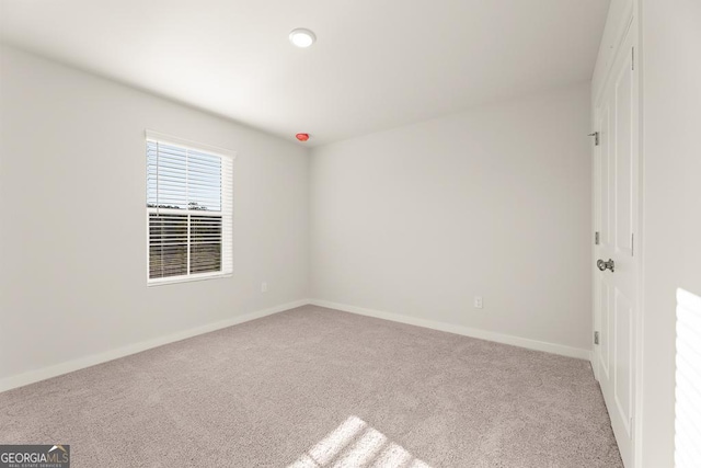 carpeted empty room with baseboards