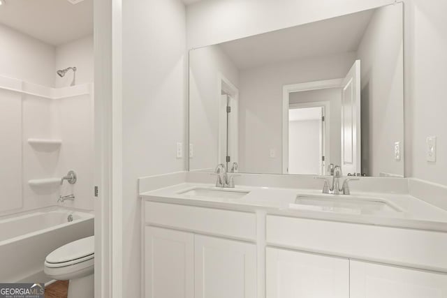 bathroom featuring a sink, washtub / shower combination, toilet, and double vanity