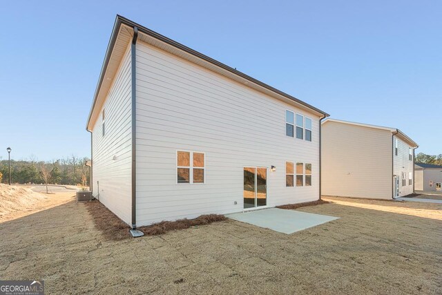 rear view of house with central air condition unit and a patio