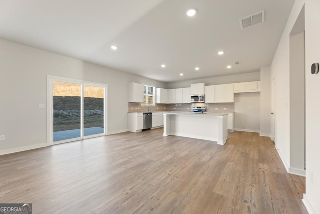 kitchen with stainless steel appliances, recessed lighting, white cabinetry, and visible vents