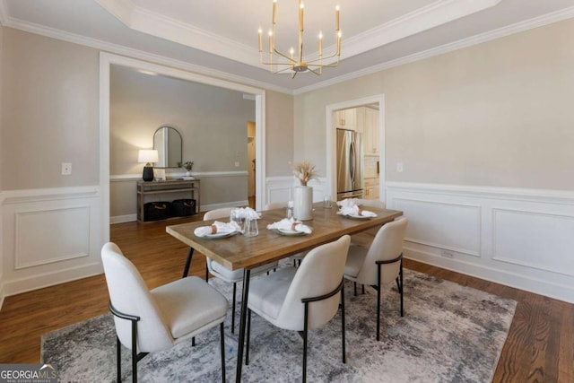 12892 Waterside Dr, Milton, GA 30004 - dining room with a raised ceiling, a decorative wall, a chandelier, a wainscoted wall, and wood finished floors