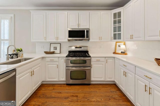 12892 Waterside Dr, Milton, GA 30004 - kitchen featuring crown molding, glass insert cabinets, white cabinetry, a sink, and stainless steel appliances
