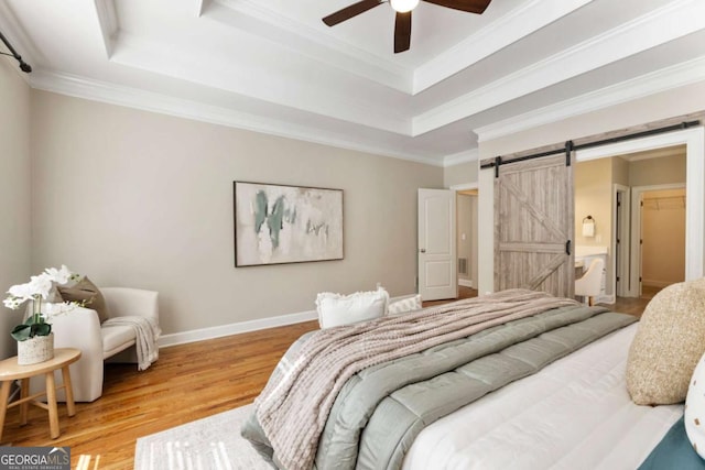 12892 Waterside Dr, Milton, GA 30004 - bedroom with ornamental molding, a barn door, wood finished floors, and a raised ceiling