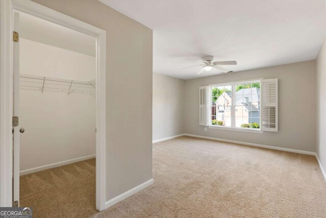 12892 Waterside Dr, Milton, GA 30004 - unfurnished bedroom featuring carpet floors, a closet, baseboards, a walk in closet, and a ceiling fan