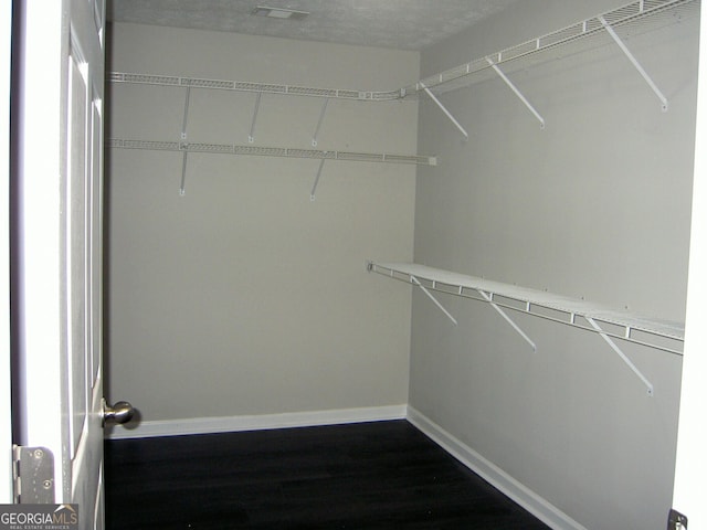 214 Oak Cir, Stockbridge, GA 30281 - spacious closet featuring visible vents and dark wood-style flooring