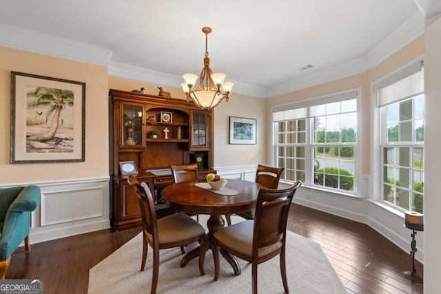 dining room with an inviting chandelier, crown molding, dark wood-style flooring, and visible vents