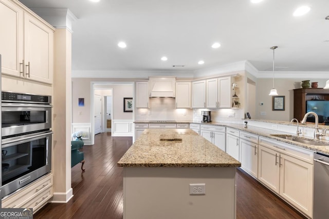kitchen featuring crown molding, appliances with stainless steel finishes, custom exhaust hood, and a sink