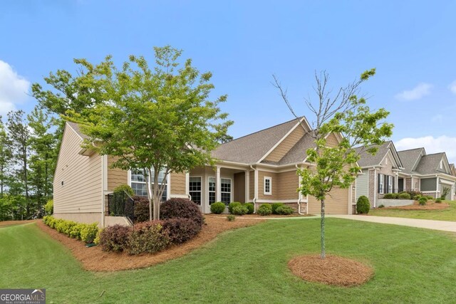 view of front of property with concrete driveway, a front lawn, and a garage